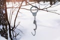 Handcuffs hang on a branch in the forest against a background of snow, a concept on the theme of escape or freedom