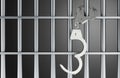 Handcuffs hanging on prison bars, arrest and incarceration concept. 3D rendering Royalty Free Stock Photo