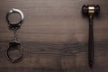 Handcuffs and judge gavel on wooden background Royalty Free Stock Photo