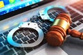 Handcuffs and judge mallet on laptop keyboard Royalty Free Stock Photo
