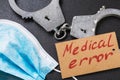 Handcuffs and a medical mask on the table. Medical error concept Royalty Free Stock Photo