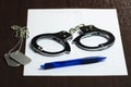 handcuffs and military badges lying on a white sheet of paper, and a blue ballpoint pen. Concept: law and justice, Royalty Free Stock Photo