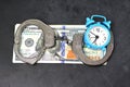 Handcuffs, money and alarm clock on dark background, bail concept