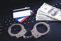 Handcuffs, money, credit cards on computer keyboard. Concept of Cyber crime and Online fraud Royalty Free Stock Photo