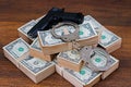 Handcuffs, money and gun on wooden table Royalty Free Stock Photo