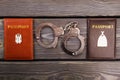 Handcuffs and passports on wood. Royalty Free Stock Photo