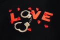 Handcuffs for sex games and hearts on black background. Sexual bdsm toy