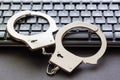 A handcuffs standing on computer keyboard. Royalty Free Stock Photo