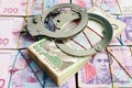 Handcuffs on Ukrainian currency hryvnia. Corruption and financial crime or penalty Royalty Free Stock Photo