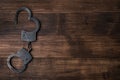 handcuffs on a wooden background top view gainst wood background for copy space Royalty Free Stock Photo