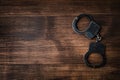 handcuffs on a wooden background top view gainst wood background for copy space Royalty Free Stock Photo