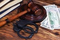 Handcuffs and a wooden gavel in front of manila folders