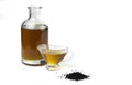 A handful of black cumin seeds and black seed oil in a glass bottle and gravy boat. Royalty Free Stock Photo