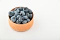 Handful of blueberries in wooden bowl isolated on white Royalty Free Stock Photo