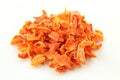 Handful of chopped and dried carrot pieces isolated on white background. Food condiment