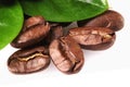 a handful of coffee beans with green leaves on a white background, Royalty Free Stock Photo