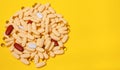 A handful of colored pills spilled out on a yellow background Royalty Free Stock Photo