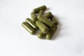 Handful of green vitamin capsules on white background