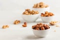 A handful of hazelnuts in a white bowl, assorted nuts on a light background. Healthy snacks, healthy fats. Copy space Royalty Free Stock Photo