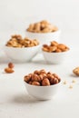 A handful of hazelnuts in a white bowl, assorted nuts on a light background. Healthy snacks, healthy fats. Copy space Royalty Free Stock Photo