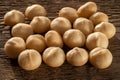 A handful of kernels of macadamia nuts on the background of coarse wood