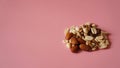 A handful of nuts on bright pink background, color background
