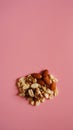 A handful of nuts on bright pink background, color background