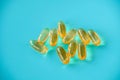 handful of omega 3 capsules on a blue background .