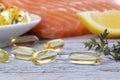 Handful of omega 3 softgels and salmon filet Royalty Free Stock Photo