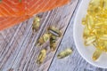 Handful of omega 3 softgels and salmon filet Royalty Free Stock Photo