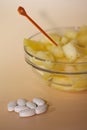 Handful of pills and cup filled with pineapple slices