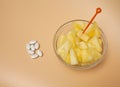 Handful pilule and cup filled with pineapple slices Royalty Free Stock Photo