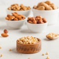 A handful of pine nuts in a wooden bowl, assorted nuts on a light background. Healthy snacks, healthy fats