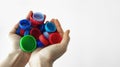 Handful of plastic caps in the hands. Concept of separate collection and recycling of plastic. Close-up. Sorting garbage