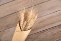 A handful of ripe wheat wrapped in kraft paper on the table Royalty Free Stock Photo