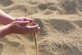 Handful of sand falling through the woman`s fingers, outdoor