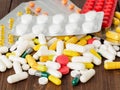 handful of scattered medicines, pills and tablets on brown wooden background Royalty Free Stock Photo