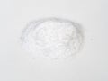 Handful of vanillin powder closeup on white