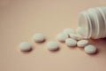 A handful of white large tablets on a peach background, vitamins Royalty Free Stock Photo