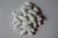 Handful of white oblong calcium citrate caplets