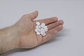 Handful of white pills or drugs in the palm of a man. Tablets prescribed by doctor. Medicine, treatments and healthcare. Close up Royalty Free Stock Photo