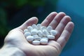 Handful of white pills in open palm. Medicine and healthcare Royalty Free Stock Photo