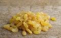 A handful of yellow raisins on a woody texture background. Royalty Free Stock Photo