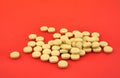 Handful of yellow tablets on red Royalty Free Stock Photo