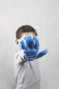 Handgesturing stop - 7 years old boy in medical face mask and gloves