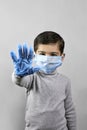 Handgesturing stop - 7 years old boy in medical face mask and gloves