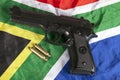 Handgun and brass bullets on a South African flag