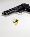 Handgun with 9mm shell casings on white table Royalty Free Stock Photo