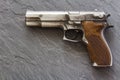 Handgun pistol on dark marble background from side
