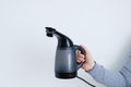 Handheld garment steamer in the hand of caucasian woman. White background